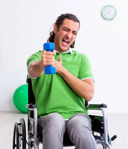Młody Człowiek Wózku Inwalidzkim Ćwiczy Pomieszczeniu — Zdjęcie stockowe