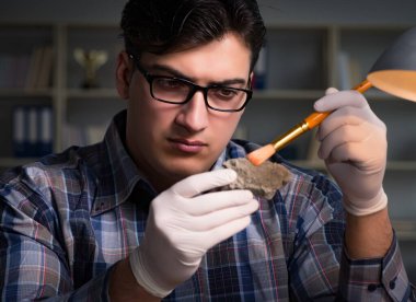 Arkeolog gece geç saatlere kadar ofiste çalışıyor.