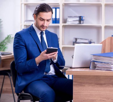 Ofiste çalışan yakışıklı genç işadamı.