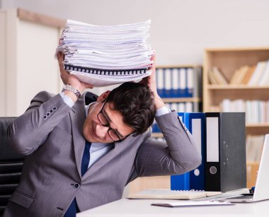 İş adamı kağıt yığınlarıyla boğuşuyor.