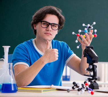 Sınıftaki genç erkek öğrenci.