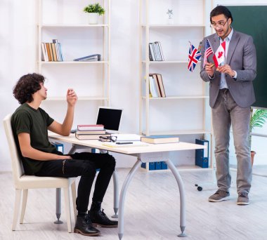 Erkek İngilizce öğretmeni ve sınıfta öğrenci.