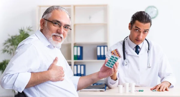 Old Man Visiting Young Male Doctor — Stock Photo, Image