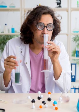 Laboratuvarda çalışan komik erkek kimyager.