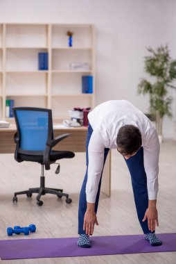 Mola sırasında spor yapan genç bir çalışan.