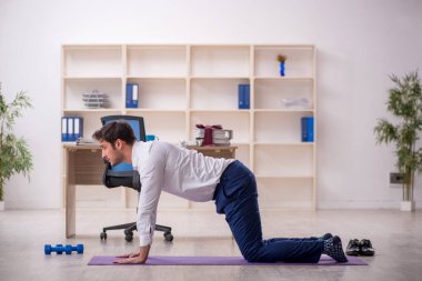 Mola sırasında spor yapan genç bir çalışan.