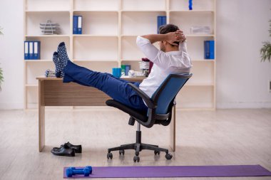 Mola sırasında spor yapan genç bir çalışan.