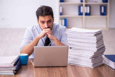 Ofisteki aşırı işten memnun olmayan genç bir erkek işçi.