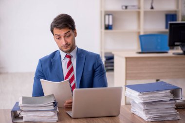 Genç işadamı işyerinde oturuyor.