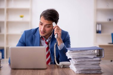 Genç işadamı işyerinde oturuyor.