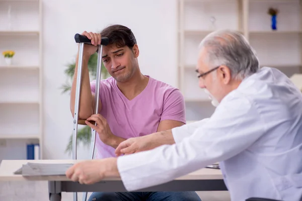 Young Leg Injured Patient Visiting Old Doctor Radiologist — Stock Photo, Image