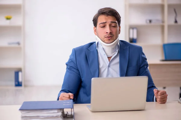 Young businessman employee after car accident in the office