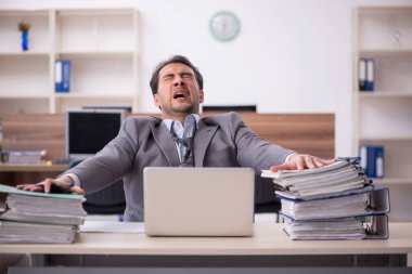 Genç işadamı işyerinde aşırı çalışmaktan memnun değil.