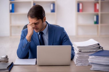 Genç işadamı ve ofiste çok fazla iş var.