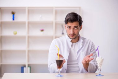 Laboratuvarda alkolsüz içeceği inceleyen genç bir kimyager.