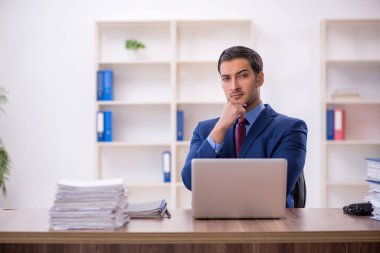 Genç işadamı ve işyerinde çok fazla iş var.