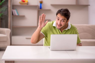 Genç erkek serbest çalışan salgın sırasında evden çalışıyor.