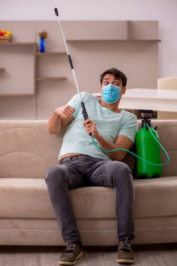 Genç müteahhit evde haşere kontrolü yapıyor.