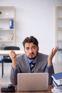 Genç işadamı ofisteki aşırı işten memnun değil.