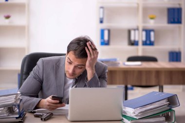 Ofisteki aşırı işten memnun olmayan genç bir çalışan.