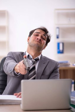 Ofisteki aşırı işten memnun olmayan genç bir çalışan.