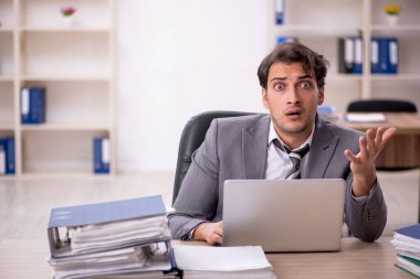 Ofisteki aşırı işten memnun olmayan genç bir çalışan.