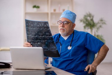 Klinikte çalışan yaşlı bir radyolog.