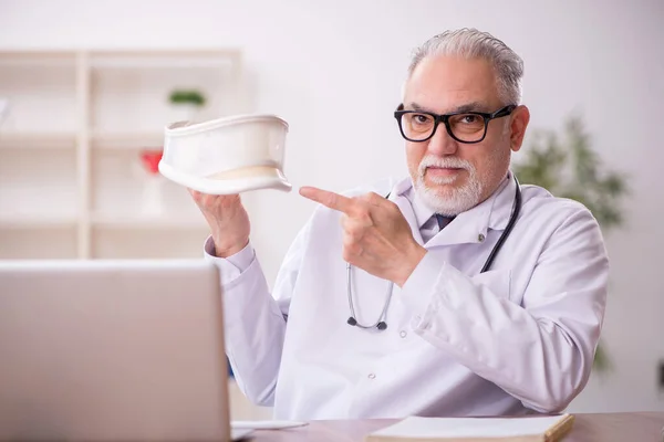 Yaşlı Erkek Doktor Klinikte Boyunluk Tutuyor — Stok fotoğraf