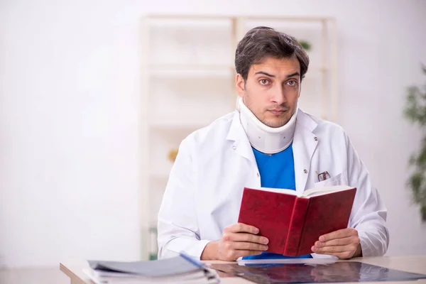 Young doctor holding neck brace
