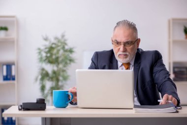 Ofiste çalışan eski bir işadamı.