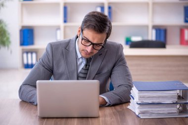 Ofisteki aşırı işten memnun olmayan genç bir çalışan.