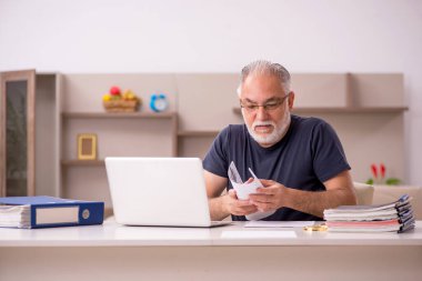 Yaşlı adam salgın sırasında evden çalışıyor.