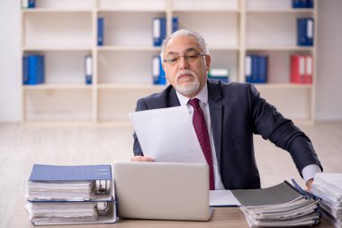 Ofiste çalışan eski bir işadamı.