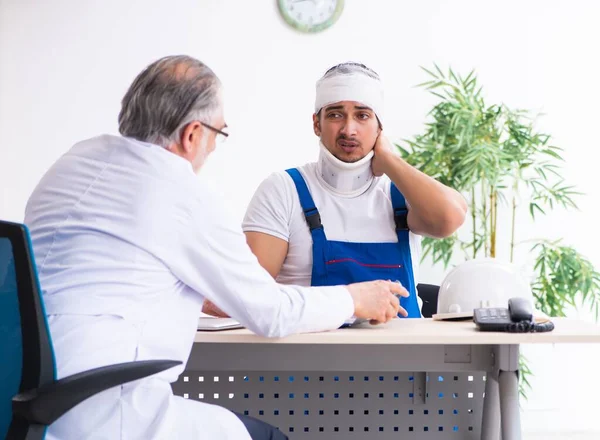 Young Male Contractor Visiting Old Doctor — Stock Photo, Image