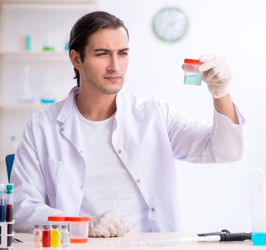 Laboratuvarda çalışan genç erkek kimyager.