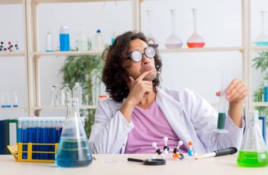 Laboratuvarda çalışan komik erkek kimyager.