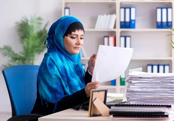 The female employee in hijab working in the office