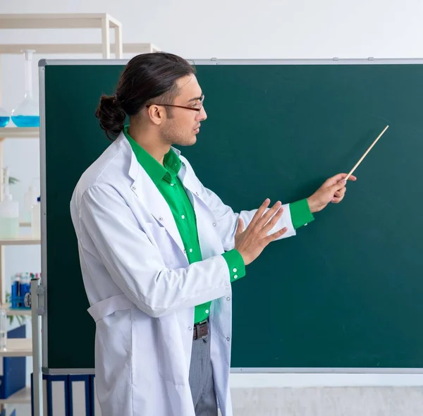 那位年轻的化学老师站在黑板前 — 图库照片