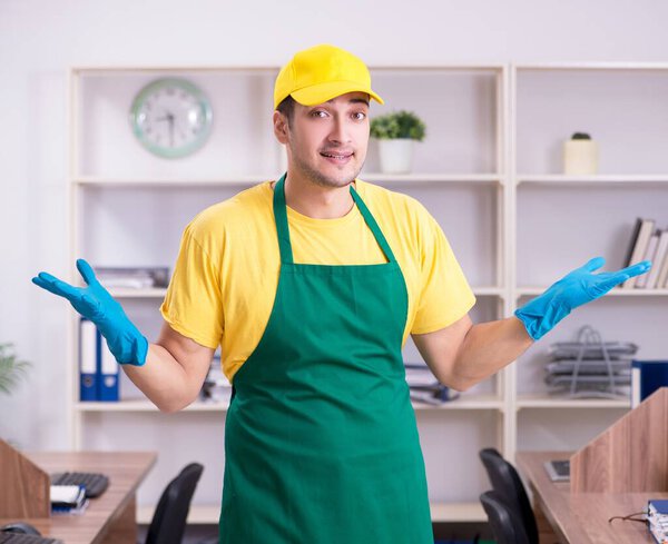 Молодой мужчина-подрядчик убирает офис