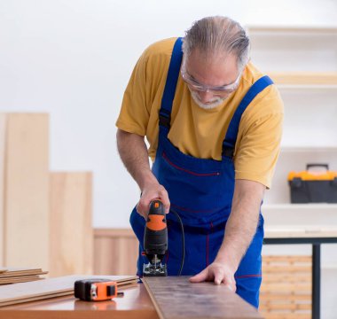 Atölyede çalışan yaşlı erkek marangoz.