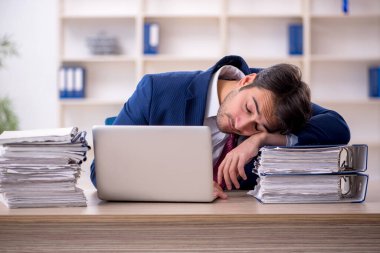 Genç işadamı ve işyerinde çok fazla iş var.