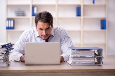 Genç işadamı ve işyerinde çok fazla iş var.