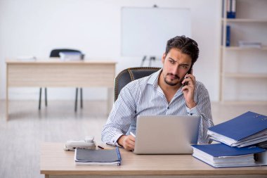 Genç işadamı ve ofiste çok fazla iş var.