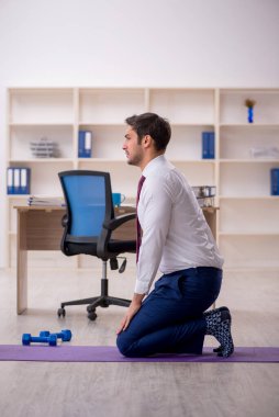 Mola sırasında spor yapan genç bir çalışan.