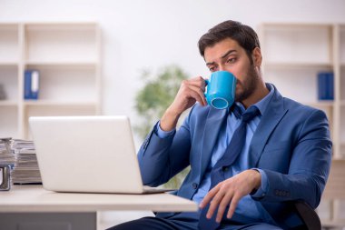 Genç işadamı ve işyerinde çok fazla iş var.