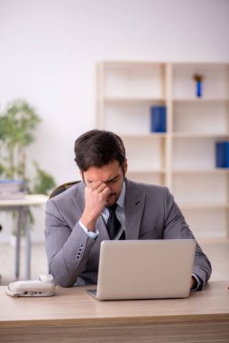 Genç işadamı ve ofiste çok fazla iş var.