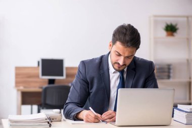 Genç işadamı işyerinde oturuyor.