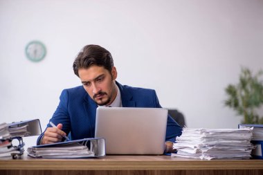 Genç işadamı ve ofiste çok fazla iş var.