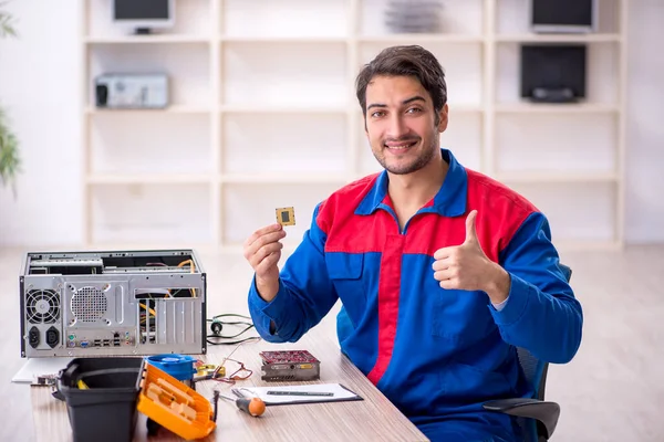 Young repairman repairing computer at workshop