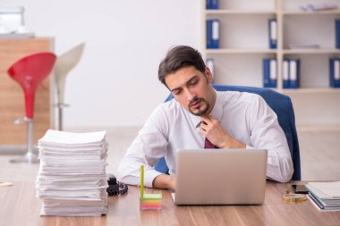 Genç işadamı ve ofiste çok fazla iş var.